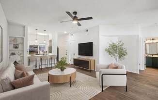 A living room with a white couch, a wooden coffee table, and a ceiling fan.