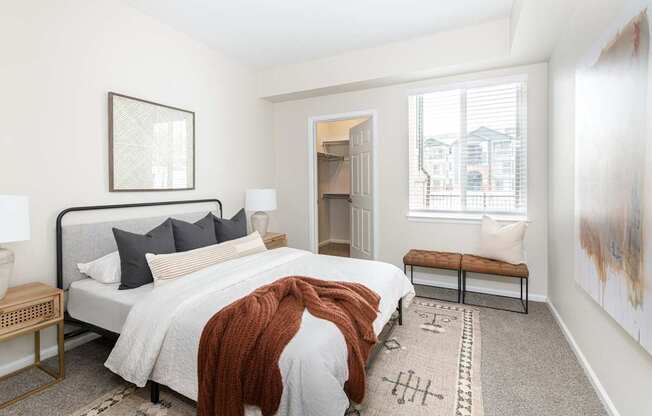 A bedroom with a large bed and a bench.