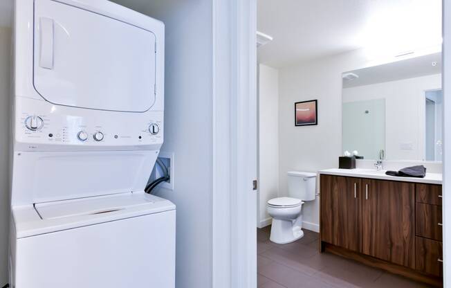 a washer and dryer in a bathroom with a toilet and a sink