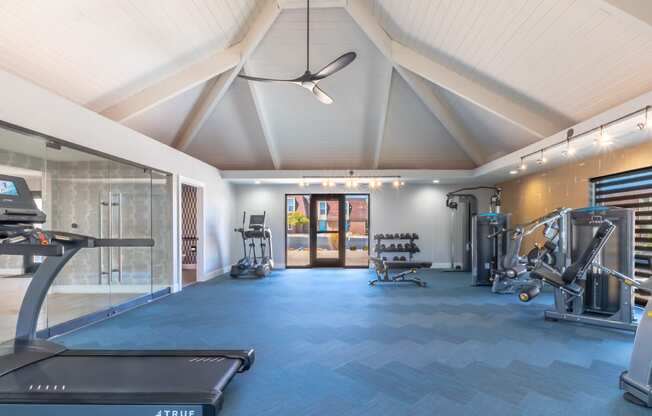 a gym with a lot of equipment and a glass door