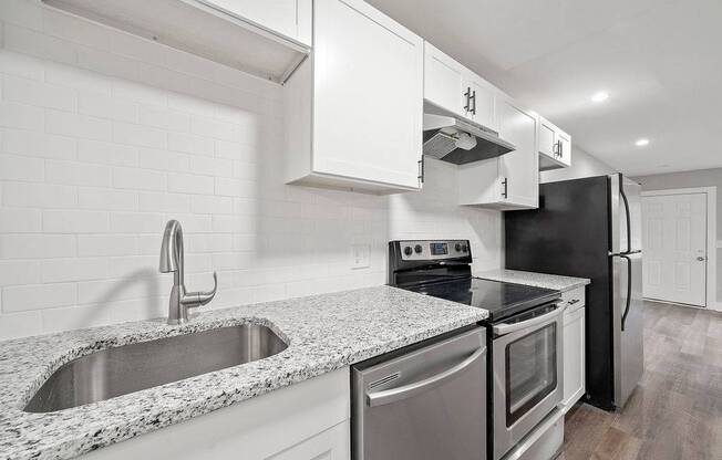 A kitchen with a black refrigerator, stove, and oven.