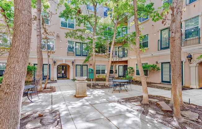 A courtyard with a bench and a tree.