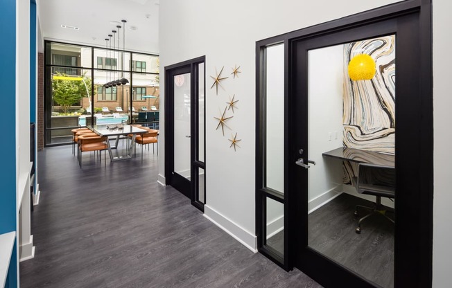 a hallway with a door open to a dining room with a table and chairs