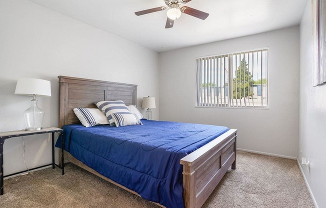 a bedroom with a bed and a ceiling fan