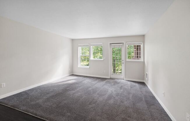 an empty living room with white walls and a carpet