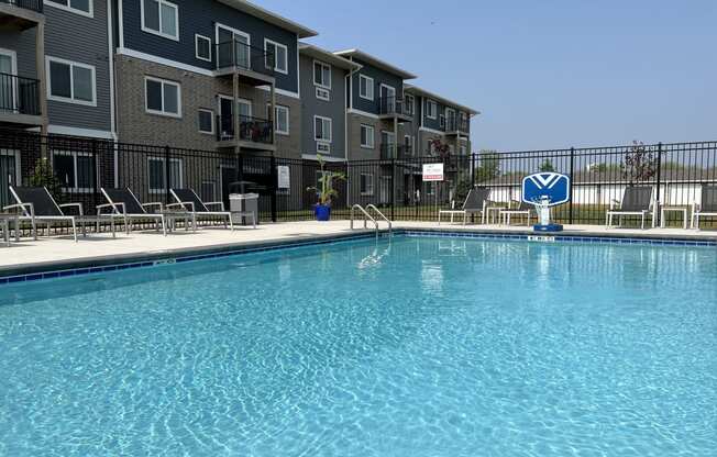 Sparkling blue pool surrounded by lounge chairs.