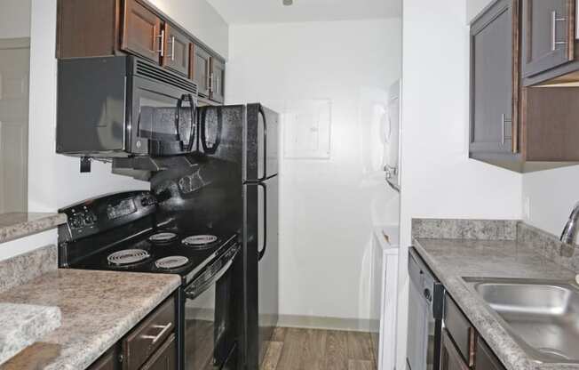 a kitchen with a stove and refrigerator and a sink at Brightwaters Apartments, Little Rock, AR,72202