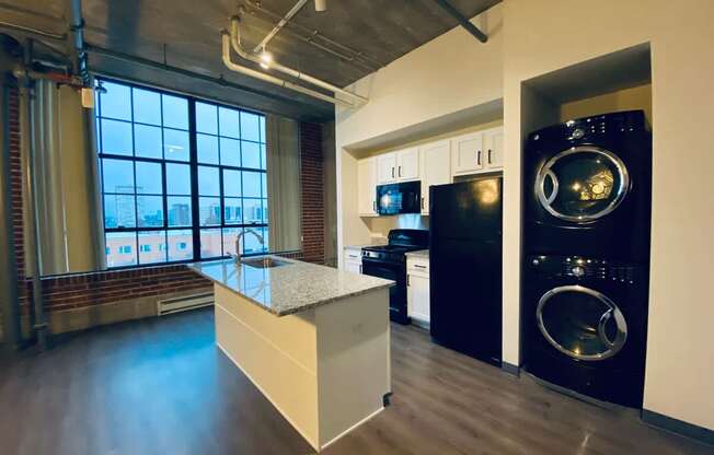 A modern kitchen with a large island and stainless steel appliances.