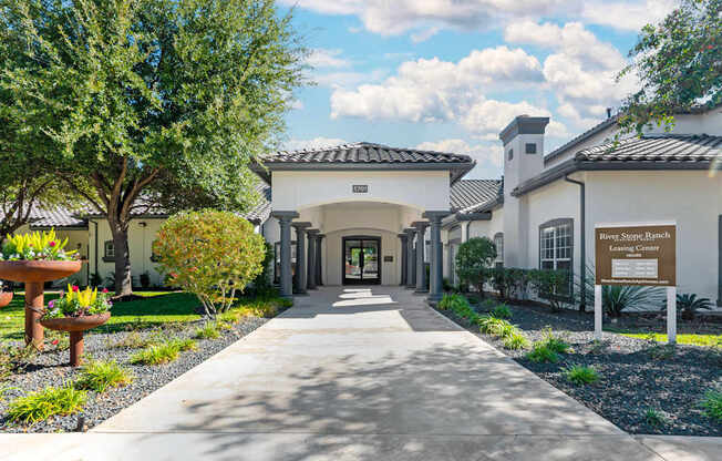 A building with a sign that says "Steve's Ranch" is surrounded by trees and plants.