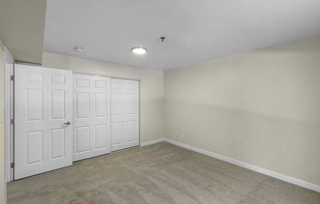 a bedroom with two closets and a carpeted floor at West Mall Place Apartment Homes, Washington, 98208