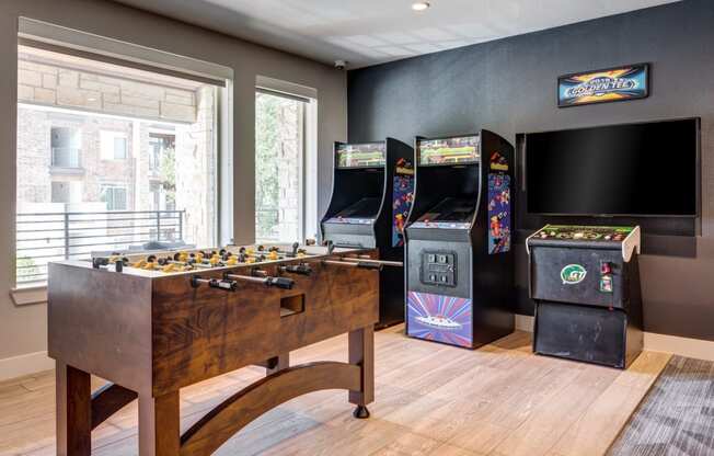 a games room with a foosball table and arcade games