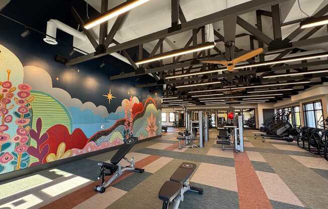A gym with a colorful mural on the wall.