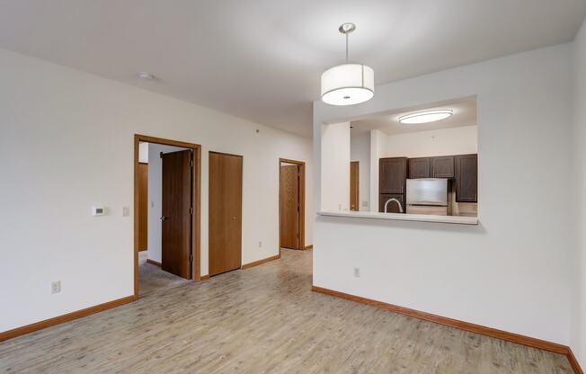 an empty living room with white walls and wood flooring