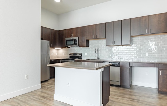 a kitchen with an island and stainless steel appliances