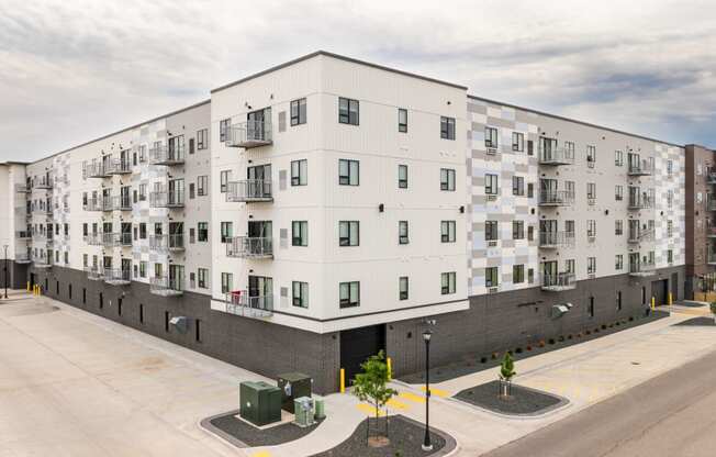 a large white apartment building with a street in front of it