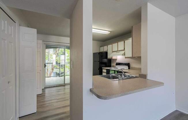 A kitchen with a refrigerator, microwave, and oven.