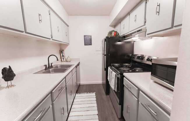 a kitchen with white cabinets and a black stove top oven