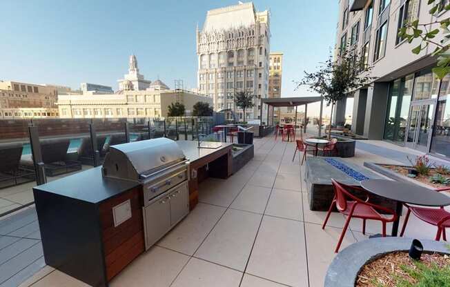 A rooftop patio with tables and chairs and a grill.