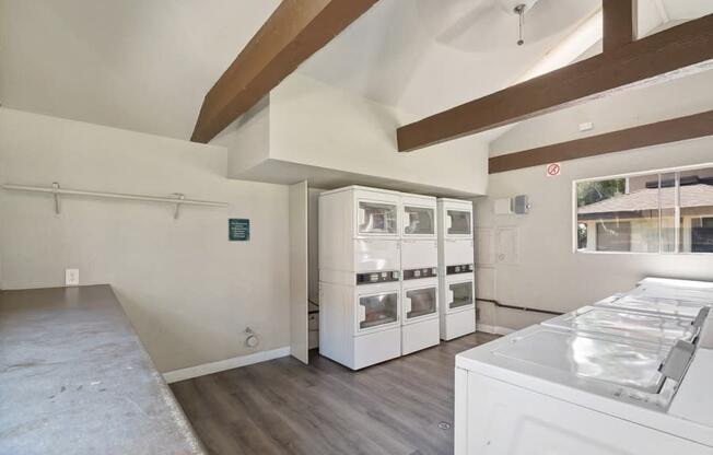 a kitchen with white appliances and a large window