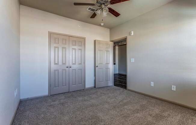 a bedroom with a ceiling fan and closet