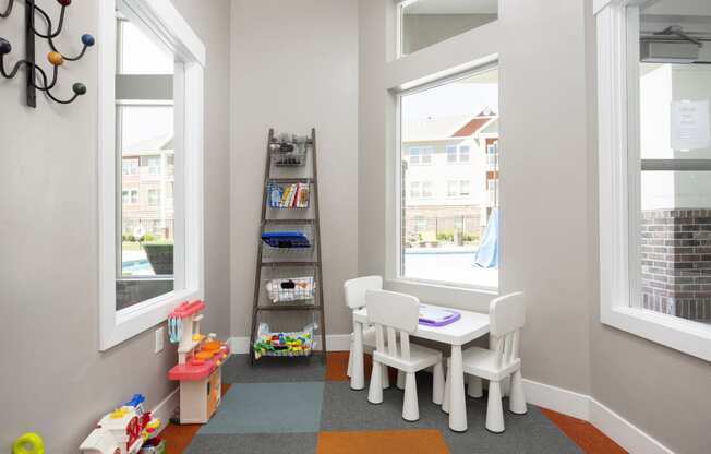 a play room with a table and chairs and a ladder with toys