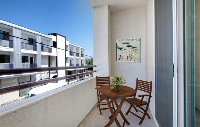 a small table and chairs on a balcony