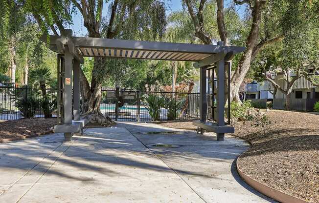 A park with a pavilion and a pond.