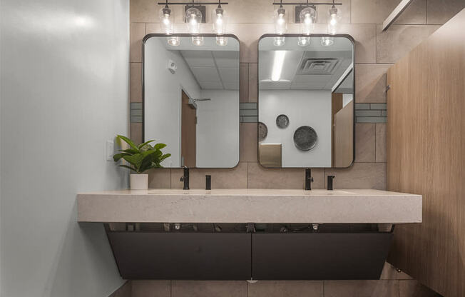 a bathroom with two sinks and two mirrors