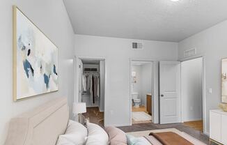 a bedroom with a white couch and a large painting on the wall