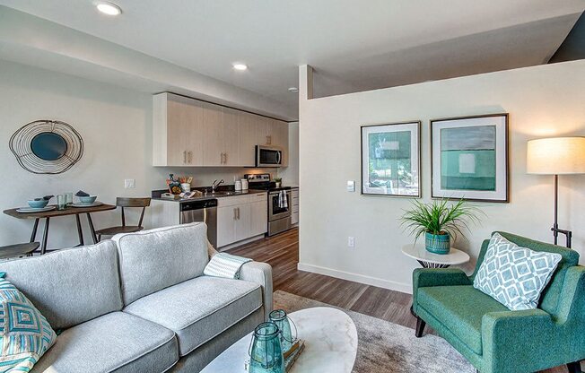 A living room with a grey couch and a green armchair. at Ravello Apartments, Redmond, WA