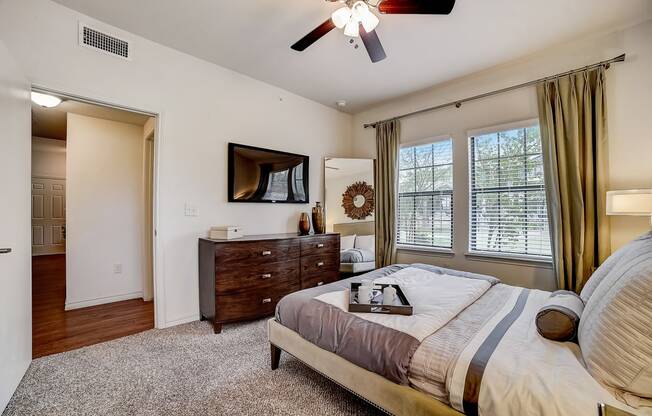 the master bedroom features a king sized bed and a flat screen tv