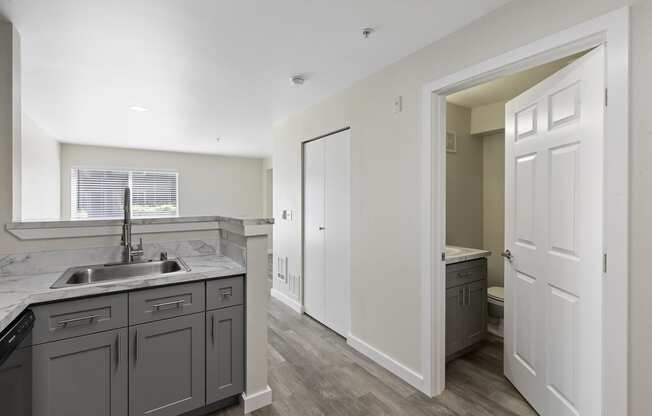 Spacious Kitchen with Plank Flooring and Open-Concept Living Area at Excalibur Apartment Homes, Bellevue, Washington 98004