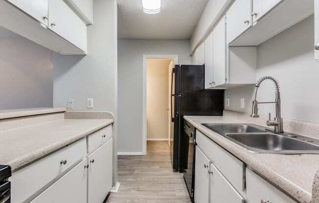 an empty kitchen with white cabinets and a sink