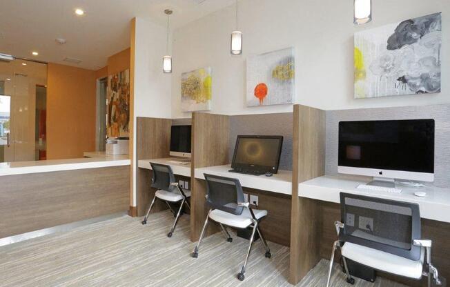 a conference room with desks and chairs and paintings on the wall