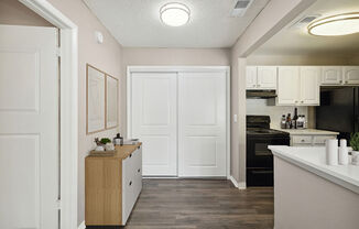 Model kitchen with white cabinets and black appliances at Vue at Baymeadows Apartments in Jacksonville, Florida