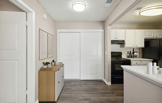 Model kitchen with white cabinets and black appliances at Vue at Baymeadows Apartments in Jacksonville, Florida