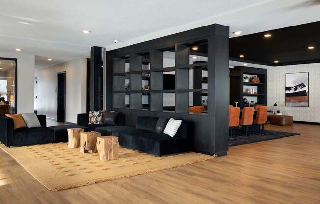 A black and wood living room with a large black bookshelf.