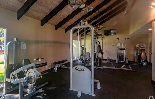 A gym with a variety of equipment including a weight machine and a rowing machine.