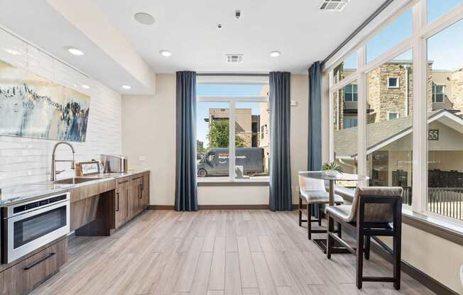 A modern kitchen with wooden floors and a large window.