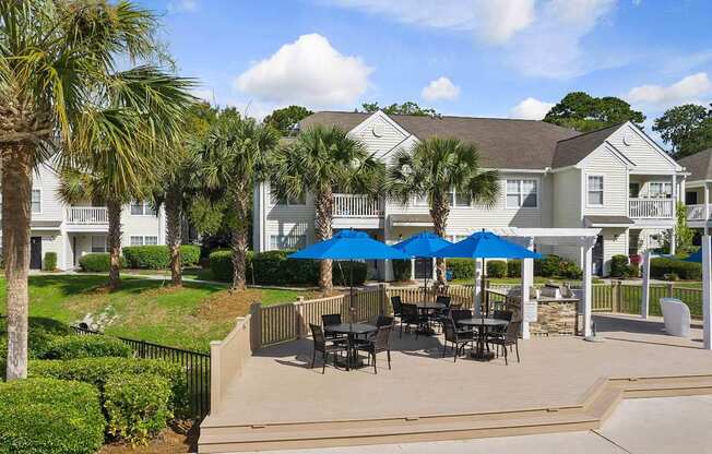 A patio with a table and chairs under a blue umbrella.