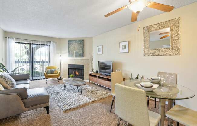 a living room with a table and chairs and a fireplace