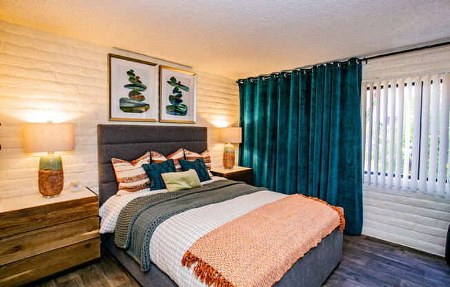 a bedroom with a bed and a window with green curtains