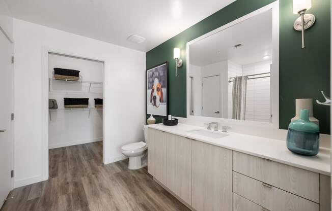 a bathroom with a large mirror and a sink and a toilet