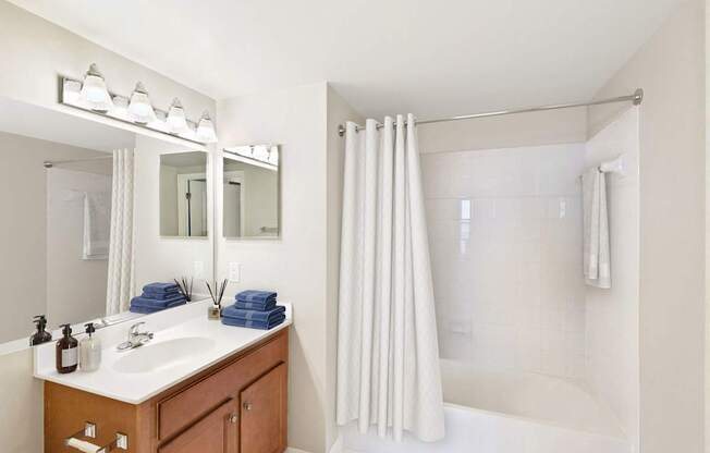 A bathroom with a sink, mirror, and shower