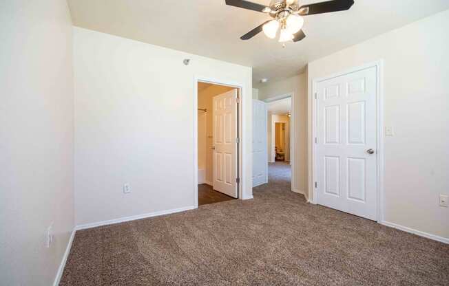 Bedroom with carpet, closet, bathroom, and ceiling fan