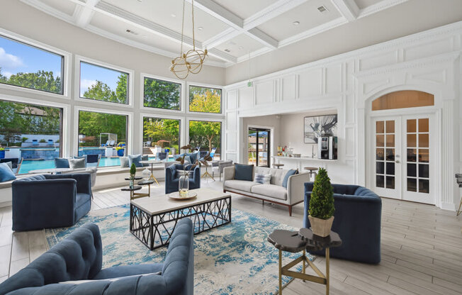 a living room with a coffered ceiling and large windows