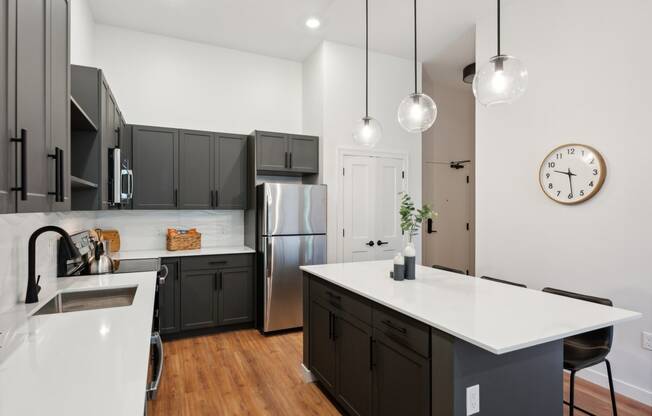 a kitchen with an island and a stainless steel refrigerator