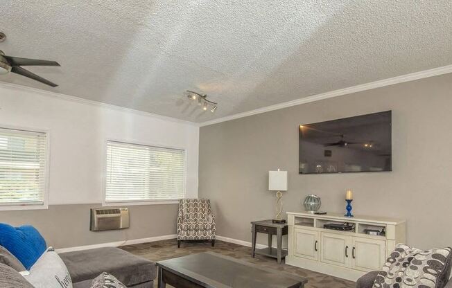 a living room with a couch and a tv at Villa La Paz Apartments, Bellflower, CA