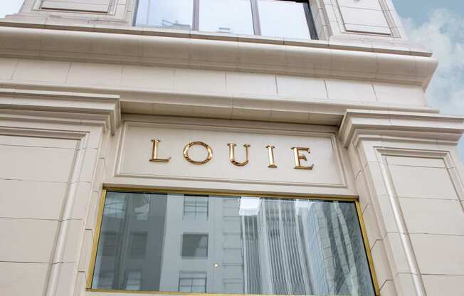 A building with a window and the word LOUIE on it.