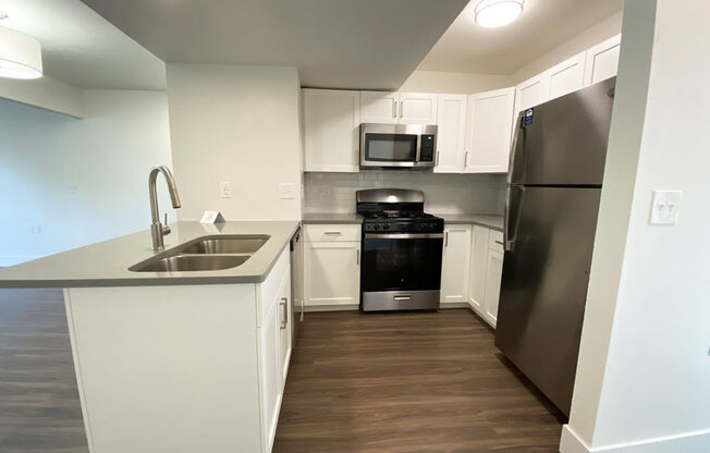 Stylish Kitchen with Breakfast Bar at Byron Lakes Apartments in Byron Center, MI